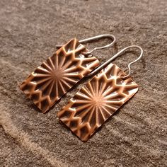 Handcrafted in my studio in Colorado, these lightweight copper earrings are embossed to add texture and are complete with sterling silver ear wire (for those sensitive ears). All of my earrings are made to order...no two earrings are ever completely alike (despite my best efforts!); therefore, your earrings may vary ever-so-slightly from the pictures.   PRODUCTION & SHIPPING  My goal is to have your earrings made and in the mail the following business day. All Teak+Copper packages ship via USPS First Class Mail (3-5 day shipping).  Priority Mail (2-3 day shipping) is available for an additional fee.  Please select your shipping option at checkout.  PACKAGING  If you would like for your earrings to come in a gift box, please select that option when checking out. Etched Copper Jewelry, Pattern Minimalist, 7th Anniversary Gifts, Etched Copper, Earrings Star, Star Burst, Embossed Metal, 7th Anniversary, Metal Shop