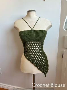 a white mannequin wearing a green crochet top