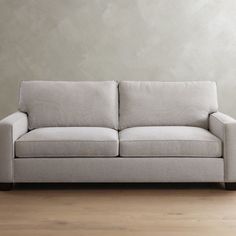 a white couch sitting on top of a wooden floor