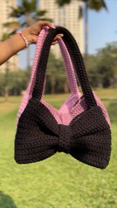 a person holding up a crocheted bow tie