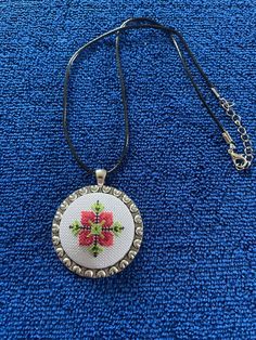 A handmade necklace with a traditional Bulgarian floral pattern. It's made from the hands of a master embroiderer with over 30 years of experience in the creation of tapestries.  Materials used: multi-coloured threads; metal base; polyester cord Size: 45x45mm Price list: (Listed prices include shipping costs) UK - £30 (Royal Mail 1st Class) International - £38.85 (Royal Mail Track & Sign) Artisan Embroidered Necklaces For Festivals, Handmade Bohemian Multicolor Embroidery Jewelry, Folk Style Handmade Jewelry As Gift, Handmade Folk Style Jewelry Gift, Handmade Folk Jewelry As Gift, Bohemian Embroidered Beaded Necklaces As Gift, Handmade Folk Style Jewelry For Gifts, Artisan Embroidered Festival Jewelry, Multicolor Bohemian Embroidered Necklace