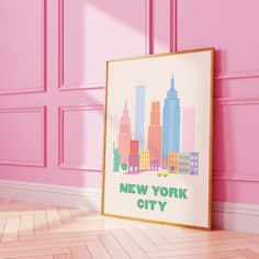 a pink room with a framed new york city poster on the wall next to it