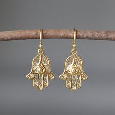 "Beautifully detailed lightweight bright shiny 18k gold vermeil Bali Hamsa charms simply dangle from 14k gold filled balled earwires. A wonderful gift for any special occasion. A matching gold necklace is available. Gold Hamsa charms: 15x19mm Total length of earrings: 1 1/4\" These earrings are also available in matte gold... www.etsy.com/listing/502019669/hamsa-earrings As the owner, maker, designer, and curator of this shop, I take great pride in providing you with jewelry that you will love t Hamsa Earrings, Judaica Jewelry, Protection Jewelry, Bat Mitzvah Gifts, Hamsa Charm, Gold Hamsa, Hamsa Pendant, Hand Of Fatima, Hamsa Hand