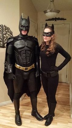 two people dressed up as batman and catwoman standing next to each other in the hallway