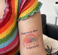 a woman with a rainbow tattoo on her arm that says, long story short i survived