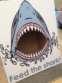 a shark with its mouth open and the words feed the shark on it's side