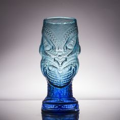 a blue glass vase sitting on top of a table