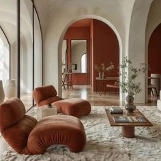 a living room filled with lots of furniture and walls painted red, white and beige