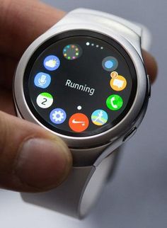 a close up of a person holding a smart watch with icons on its display screen