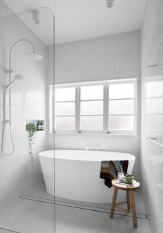 a white bathroom with a tub and shower