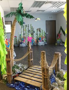 an office decorated with paper palm trees and roped off rafters for the entrance