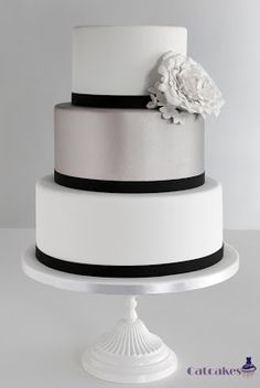 a white and black wedding cake with flowers on top