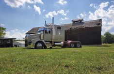 a large semi truck parked in front of a barn