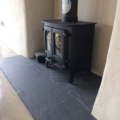 a black stove sitting in the corner of a room next to a wall and floor