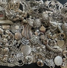 a pile of silver jewelry sitting on top of a table