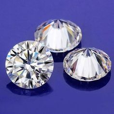 three diamond cut diamonds on a blue surface with one in the center and one in the middle