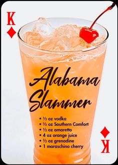 an orange drink with ice and a cherry on the top, surrounded by playing cards