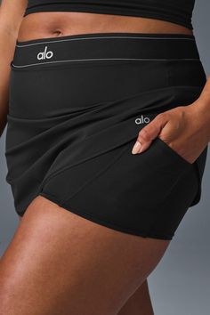 Take your look from the court to post-practice plans in the Match Point Tennis Skirt. It has a boxer-style elastic waistband (so on-trend), built-in shorts with a side pocket, and a mini-length hem. It’s made from a lightweight, slightly swishy performance fabric and has a cute, swingy fit. Wear it with a hoodie, a bra top, or even a blazer—this skirt aces the game every time. Workout Skirt, Tennis Skirt Black, Skirt With Shorts Underneath, Skirt With Shorts, Match Point, A Workout, Shopper Tote, Fitted Skirt, Bra Top