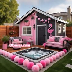 a hot tub in front of a pink house with flamingos on the wall and decorations around it