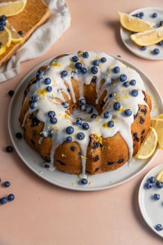 a blueberry bunt cake on a plate with lemon slices and blueberries around it