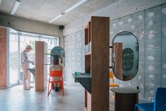 a man standing in front of a mirror next to a woman sitting at a table