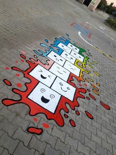 an artistic street art design painted on the sidewalk with colored paint and water drops coming out of it