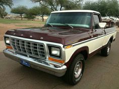 a brown and white pick up truck parked in a parking lot