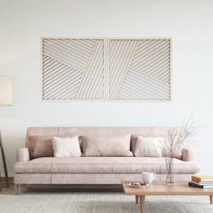 a living room with a couch, coffee table and two framed pictures on the wall