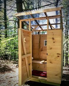 an outhouse built in the woods with wood framing