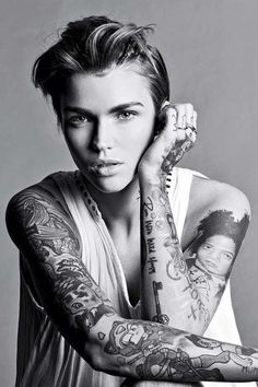 a woman with many tattoos on her arms and arm, posing for a photo in black and white