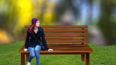 a woman sitting on top of a wooden bench in the grass next to a tree