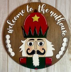 a wooden sign with an image of a nutcracker wearing a hat and holding a star