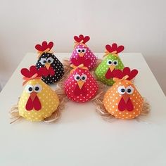 five colorful stuffed chickens sitting on top of a table next to each other with polka dots