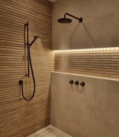 a bathroom with a shower head and hand held shower faucet in the corner