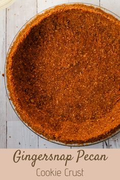 ginger snap pecan cookie crust in a glass pie plate on a white wooden table