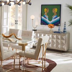 a dining room table with chairs and a large painting on the wall behind it,