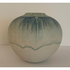 a green and white vase sitting on top of a table