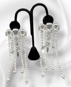 "Dripping with Ice": Dare to dazzle with our "Dripping with Ice" Earrings! These stunning earrings are fully adorned with blingy strands of dripping rhinestones, making you the star of any event. Elevate your style and sparkle with confidence! Approximately 5.5" long, 2 inches in width. Weight: approximately 1.3 ounces for the pair. Long Drop Rhinestone Party Jewelry, Party Crystal Drop Earrings, Party Long Drop Rhinestone Jewelry, Party Jewelry With Rhinestones In Long Drop Shape, Sparkling Drop Chandelier Earrings For Party, Party Jewelry With Long Drop Rhinestones, Drop Crystal Earrings For Party, Party Long Drop Chandelier Earrings, Silver Crystal Bling Earrings For Party