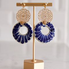 These minimalist and elegant, one of a kind drop earrings were created by joining the traditional and vibrant Talavera from Puebla and adding the finishing touch of our talented artisan partner from Mexico City. The fusion of these two talents creates a modern, bohemian and versatile piece of wearable art. Perfect for everyday wear, special occasions or as a gift for that special someone in your life. These statement earrings are embellished with 14K gold plated circular motifs. They are 2.5"in Artisan Handmade Blue Earrings, Handmade Artisan Blue Earrings, Artisan Blue Earrings, Artisan Blue Earrings With Artistic Design, Artisan Blue Drop Earrings, Unique Handmade Ceramic Jewelry, Bohemian Blue Earrings With Artistic Design, Blue Bohemian Earrings With Artistic Design, One-of-a-kind Elegant Blue Earrings