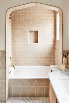 a bath room with a sink and a bath tub next to a window in the wall