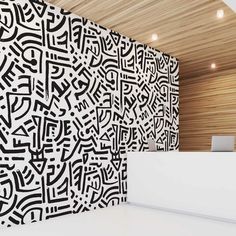 a white counter sitting in front of a wall with black and white designs on it