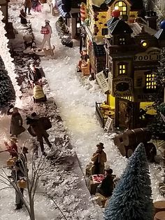 a christmas village with people walking around it