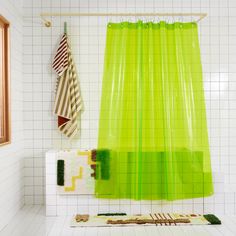 a green shower curtain in a bathroom with white tile