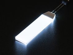 an electronic device is lit up on a black surface with light coming from the top