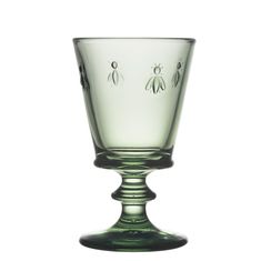 a green glass cup with bees on it