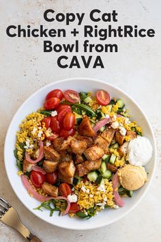 a white bowl filled with chicken, rice and veggies next to a fork