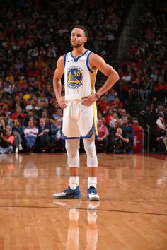 a man standing on top of a basketball court with his hands on his hipss