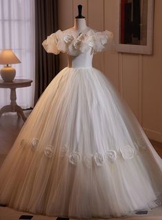 a wedding dress on display in a room with a lamp and window behind it,