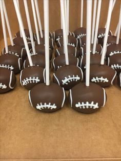 chocolate covered cake pops with white and black footballs on them are ready to be eaten