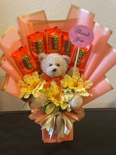 a teddy bear sitting in a vase filled with candy